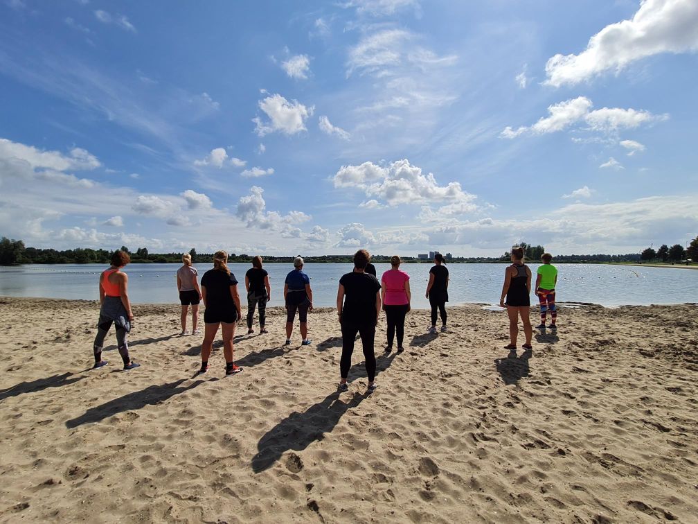 mensen die op een strandje staan en gaan bewegen